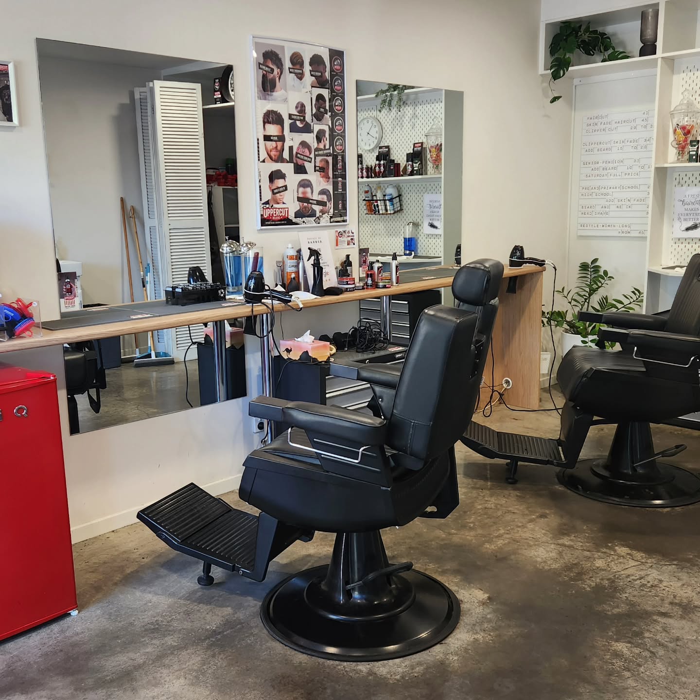 Two barber chairs and the front bench inside the shop